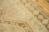Distressed texture of a vintage Afshar carpet with faded sand, coffee, and sea foam geometric patterns.