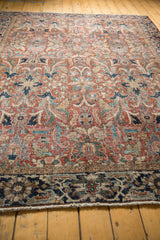 Vintage Heriz carpet's navy blue border with expressive leaves and brick red floral field.