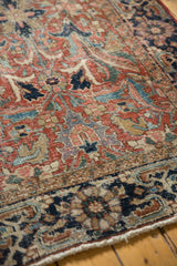 Hand-knotted Heriz carpet fringe and patterned border, showcasing navy blue, brick red, and sand floral motifs.