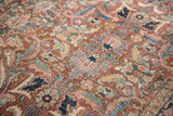 Vintage Heriz carpet: brick red, navy, green floral pattern, visible knot heads.