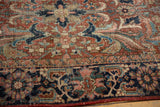 Close-up of vintage Heriz carpet's expressive floral pattern in brick red, navy, and copper green.