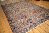 Dramatic expressive floral motifs in brick red and navy on a vintage Persian carpet.
