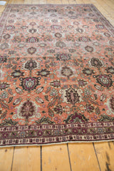 Distressed vintage Veramin carpet border, showing faded copper, burgundy, and slate blue motifs.