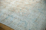 Distressed texture of vintage Sparta carpet showing faded vinery, sky blue buds, and visible foundation.