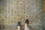 Distressed vintage Afshar rug, allover geometric and floral motifs, worn pile, muted earthy tones.