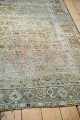 Lower border of a distressed vintage Afshar rug with slate blue and sage geometric floral motifs.