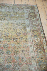 Afshar rug's geometric floral patterns, worn pile exposing foundation, and muted dusty rose tones.