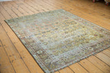 Artfully worn vintage Afshar rug displaying faded floral cross sections and a muted color palette.