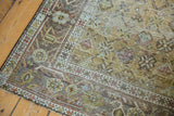 Distressed vintage Afshar rug corner, with geometric floral motifs in muted rose, sage, and slate.