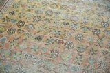 Distressed Afshar rug texture with faint floral geometry in dusty rose and sage.