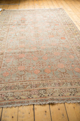 Distressed Khotan carpet's pale grapefruit red pomegranate and vine pattern on silver, showing even wear.