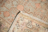 Khotan rug corner showing distressed pile, exposed foundation, fringe, and numbered reverse.
