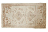 Distressed vintage Oushak rug featuring double medallions in antique ivory and pale coffee brown.