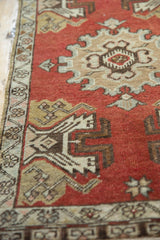 Corner detail of vintage Oushak rug, showing germinating planter design on brick red field.