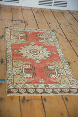 Corner detail of brick red vintage Oushak rug with germinating planter design and intact selvage.