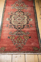 Scrolling Rococo stylized floral medallion on abrashed brick red vintage Oushak runner.