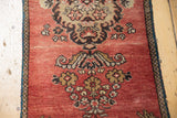 Stylized floral bouquet and low pile texture on brick red vintage Oushak rug.