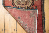Vintage Oushak rug corner revealing brick red pile, beige pattern, and hand-knotted foundation.