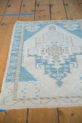 Distressed low pile of the geometric Oushak medallion in ivory, beige, and teal.