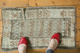Vintage Oushak rug texture showing low pile, pale brown boteh, and dark etched crab border.