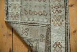 Reverse and secured edges of a distressed vintage Oushak rug mat, with etched foundation.