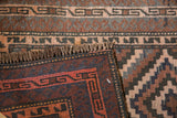 Hand-knotted Belouch rug fringe, woven backing, and geometric patterns in brown, navy, rose.