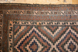 Belouch rug's intricate geometric border and field pattern with brown, navy, and rose tones.