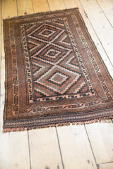 Dark brown fringe and simplistic geometric border detail of the vintage Belouch runner.