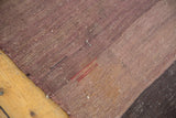 Vintage Turkish Kilim close-up with striated mauve, brown flat weave, and visible red stitches.