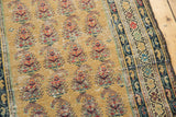 Dusty gold saffron Malayer runner with repeating paisley botehs, dark blue border, and mostly even wear.