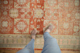 Even wear and low-pile texture of a distressed Khotan rug in cherry red, beige, and pale seafoam green.