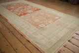Angled view of a vintage Khotan runner highlighting its lovely abrashes and low, worn pile.