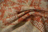 Folded vintage Khotan rug showing distressed low-pile texture and cherry red geometric design.