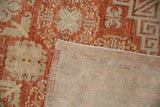 Folded corner of a vintage Khotan rug reveals the hand-knotted foundation and secured side binding.