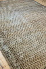 Distressed texture of the Mir Serbend carpet, revealing faded ivory boteh pattern and border.