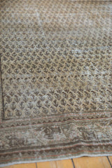 Distressed vintage Mir Serbend carpet showing worn antique ivory boteh pattern and border.