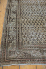 Distressed hand-knotted Mir Serbend carpet corner with repeating boteh and exposed foundation.