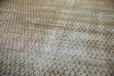 Vintage distressed Mir Serbend rug texture showing beige, ivory, and charcoal boteh pattern.