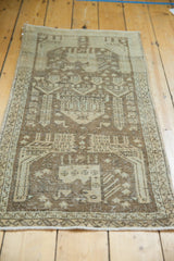 Distressed vintage Sivas rug runner corner, showing worn pile, ivory geometric motifs, and secured end.