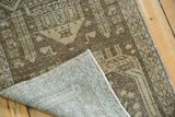 Distressed pile with faint beige and bronze tones, revealing the hand-knotted foundation.
