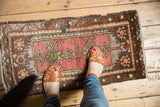 Vintage Oushak mat featuring a dusty blush rose field, chocolate brown border, and geometric patterns.