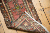 Folded corner of a Turkish Oushak rug, showing hand knotted foundation, fringe, and intact selvage.