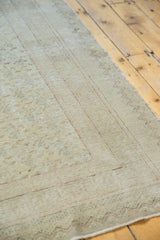 Distressed vintage Kayseri carpet with worn pile, muted floral designs, and an ivory zig-zag border.