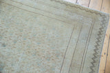 Distressed Kayseri rug corner, zig-zag border, faded floral field, light foundation.