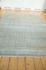 Distressed beige Kayseri rug showing charcoal brown zig-zag border and finished edge.
