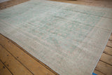 Faded seafoam green and ivory vinery motifs on the distressed vintage Sparta carpet.