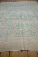 Even wear revealing pale seafoam green and ivory floral vinery on a distressed Sparta carpet.