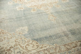 Distressed vintage Sivas carpet with abrashed faded blue field and ivory motifs.