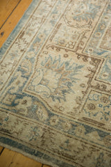 Angled detail of the vintage distressed Sivas carpet's faded blue, bronze, and ivory pile.