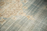 Distressed faded denim blue field, showing faint foundation and ivory scrolling arabesques.